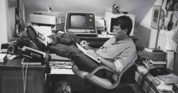 Onde nasceram algumas das mais famosas obras Foto do escritor Stephen King, sentado em uma cadeira, com os pés sobre a mesa e escrevendo em uma prancheta apoiada no colo.